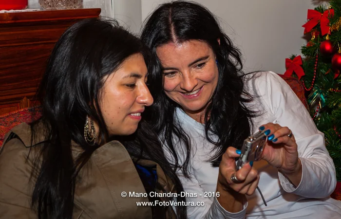 Two women looking at a camera together at Christmas