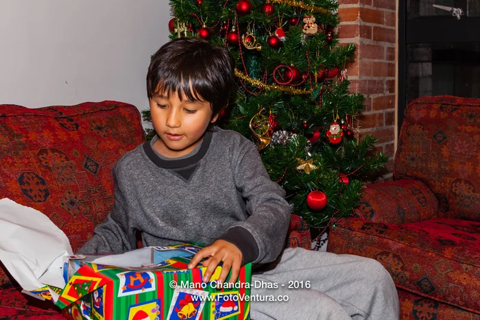 Bogota, Colombia - Child excitedly opens Christmas present