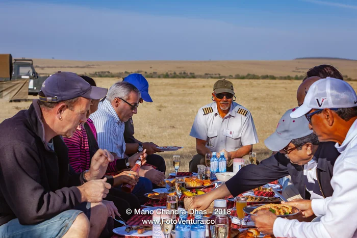Kenya, East Africa - Tourists Enjoying A Champagne Breakfast On the Masai Mara National Reserve After An Early Morning Hot Air Balloon Safari