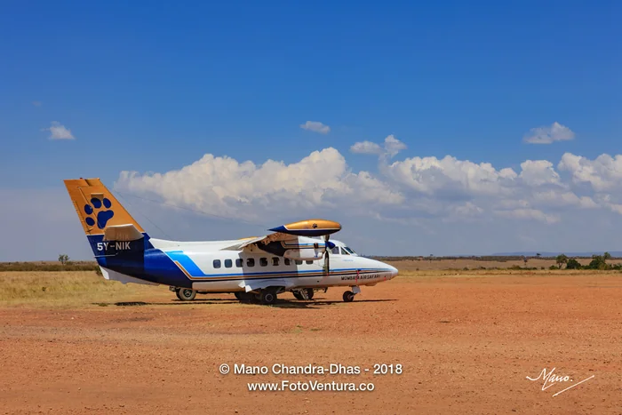 Masai Mara, Kenya - Boarding In Progress With A Small Twin-engine Turboprop Airplane At The Olkiombo Airstrip On The Masai Mara; Blue Skies Meet The Mara In The Far Horizon In The Background