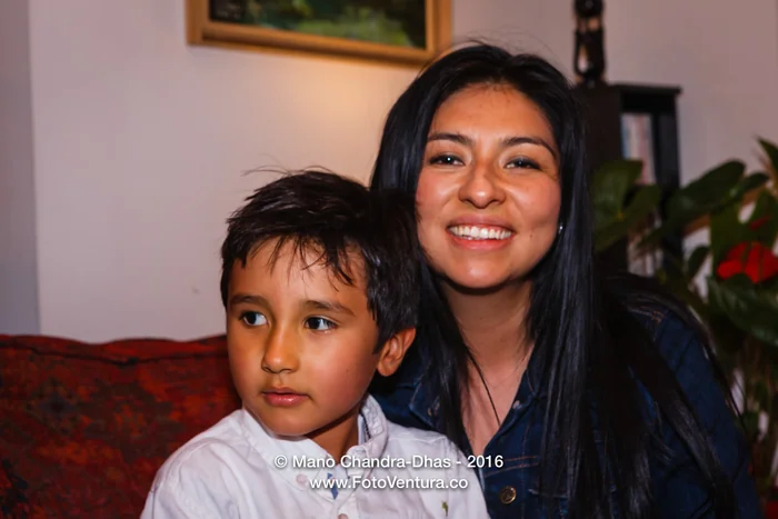 A young woman and a boy smiling at home