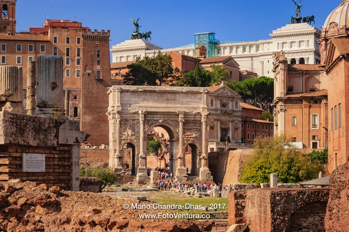 Rome, Italy: Tourists stream through the Arch of Septimius Severus.