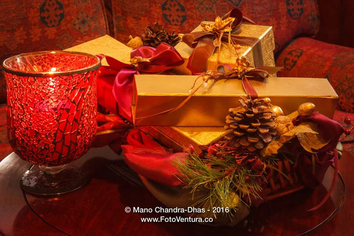 Christmas - gifts in gold boxes; ribbons, pine cone and candle.