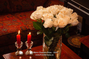 Cream coloured roses and red unlit candles