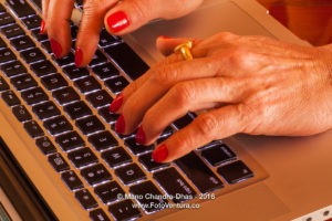 Older Latin lady's hands on laptop computer keyboard