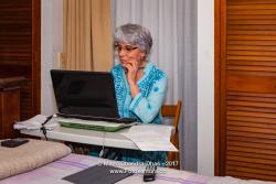 Senior Hispanic Lady With Silver Hair, Working From Home On Her Computer