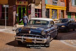 Bogotá, Colombia - Traffic Drives Down a Narrow Street in the Historic La Candelaria