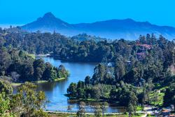 Kodaikanal, South India - Looking Down At Kodaikanal Lake From A Higher Elevation In The Colonial Town In The State Of Tamil Nadu; In The Far Background Is The Peak Known Locally As Perumal Malai