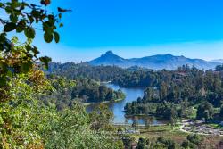 Kodaikanal, South India - Looking Down At Kodaikanal Lake From A Higher Elevation In The Colonial Town In The State Of Tamil Nadu; In The Far Background Is The Peak Known Locally As Perumal Malai. No people.