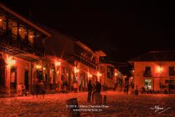 Colombia, South America - Tourists And Some Local Residents On The Eastern Corner Of The Plaza Mayor In The Historic 16th Century Town of Villa de Leyva